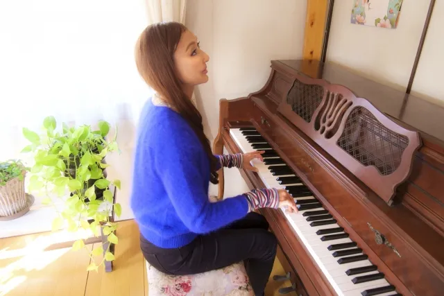 大人になってからピアノを趣味として始めた女性が、穏やかな表情で鍵盤に向き合う