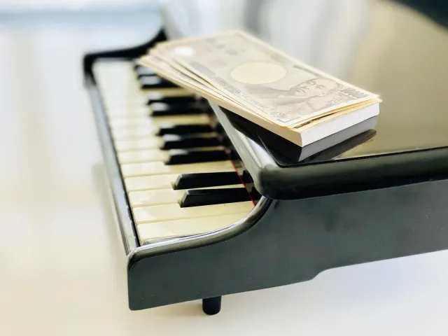 ピアノとお金で月謝・レッスン費用をイメージする写真